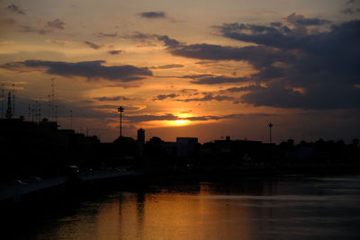 Silhouette buildings against sky during sunset