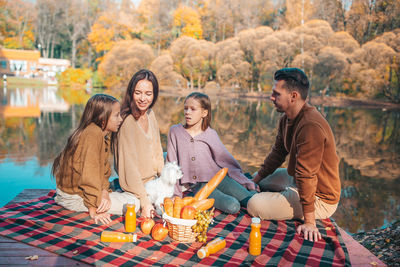 Family sitting by lake