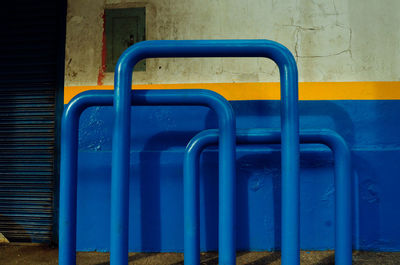 Close-up of blue metal pipes against wall