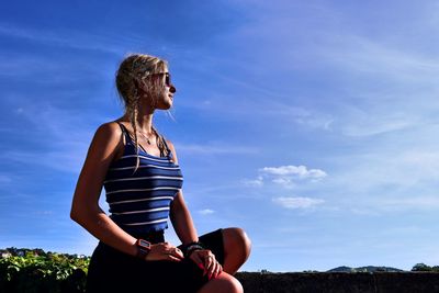 Woman standing against blue sky