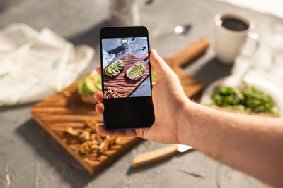 Midsection of man using mobile phone on table