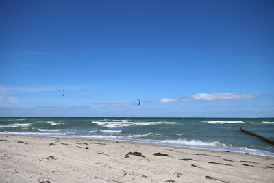 Scenic view of beach against blue sky