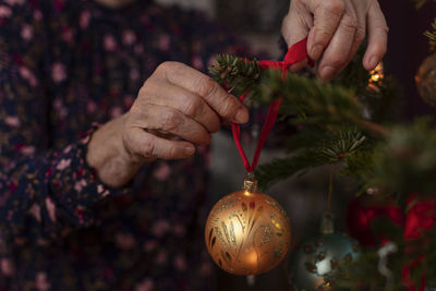 Woman's hands decorating christmas tree
