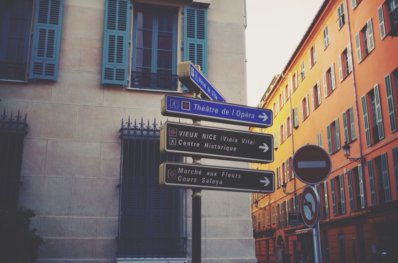 architecture, building exterior, built structure, text, low angle view, city, building, western script, window, communication, residential building, city life, residential structure, non-western script, outdoors, day, information sign, road sign, sign, clear sky