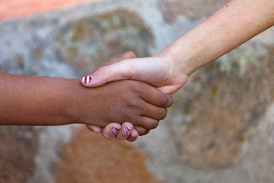 Close-up of girls shaking hands