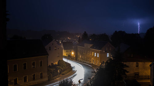 Illuminated city against sky at night