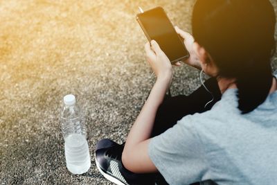 Midsection of man using mobile phone while sitting on table