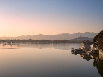 Scenic view of lake against clear sky during sunset