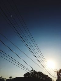 Low angle view of electricity pylon against clear sky