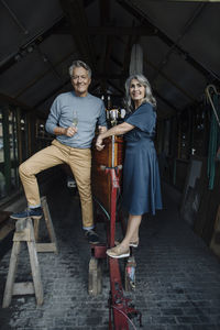 Senior couple in a boathouse with glass of champagne