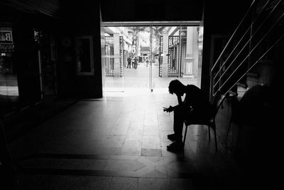 Woman sitting in corridor