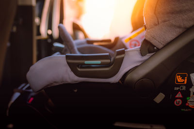 Midsection of man using mobile phone while sitting in car