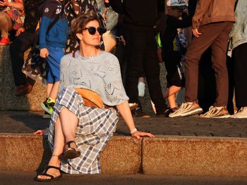 Portrait of woman standing on footpath