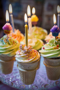 Close-up of lit candles on desserts