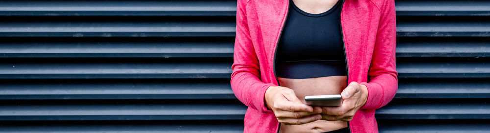 Midsection of woman holding mobile phone