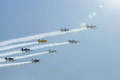 Low angle view of kites flying against clear sky