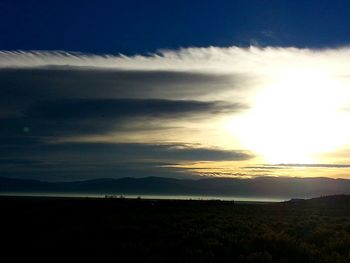 Scenic view of silhouette field against sky at sunset