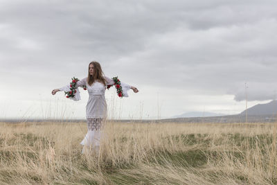 Woman standing on field against sky