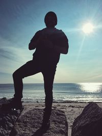 Man standing at beach against sky