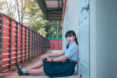 Portrait of smiling young schoolgirl at balcony