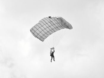 Low angle view of person paragliding against sky