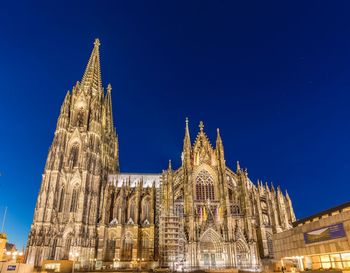 Low angle view of illuminated cathedral in city against sky at dusk