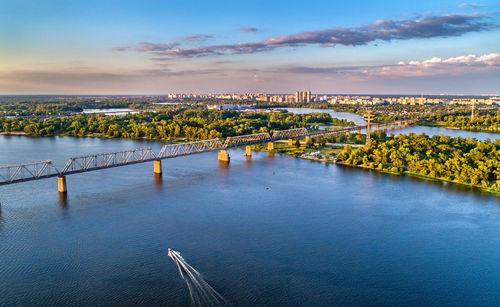 Bridge over river against sky in city