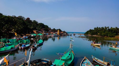 Boats moored in canal against sky. 