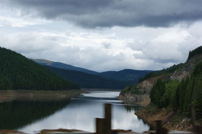 Scenic view of lake by mountains against sky