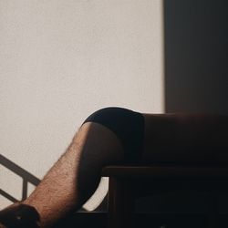 Low section of woman sitting on chair at home