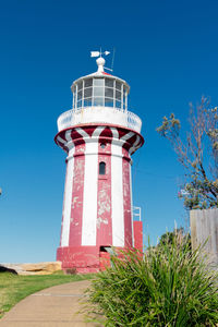 Low angle view of lighthouse against clear blue sky