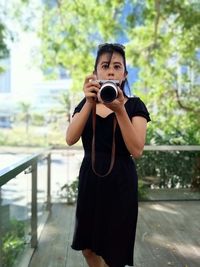 Portrait of woman photographing with camera