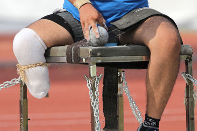 Close-up of senior man sitting on metal