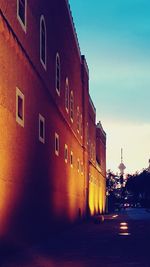 Street amidst buildings against sky at dusk