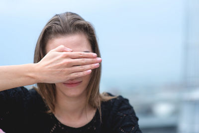 Woman covering eyes with hands