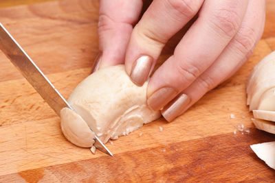 Close-up of person hand holding bread on cutting board