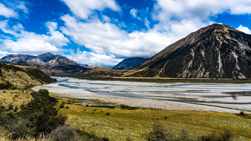 Scenic view of lake by mountains against sky