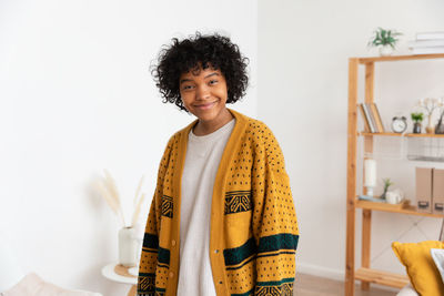 Portrait of young woman standing against white background