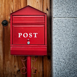 Close-up of red mailbox outside building