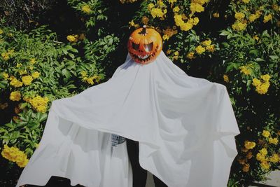 Portrait of ghost standing infront flowers