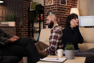 Side view of woman using mobile phone while sitting in office