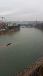 Built structure by river against sky