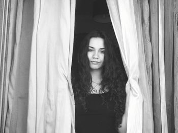 Portrait of beautiful young woman standing at home