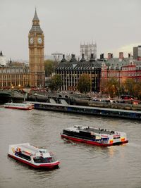 Boats in river with buildings in background