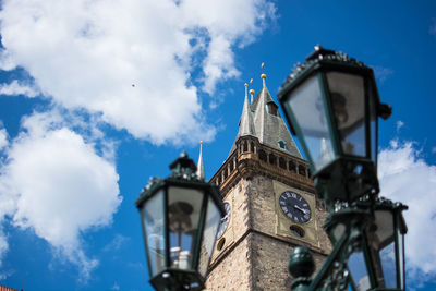 Low angle view of gas lights and prague astronomical clock against sky