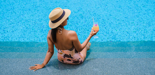 Rear view of woman sitting on inflatable ring