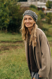 Portrait of young woman standing on field