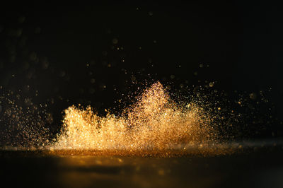 Close-up of gold glitter against black background