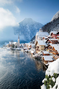 Scenic view of townscape by lake during winter