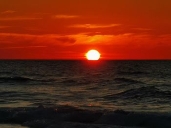 Scenic view of sea against orange sky